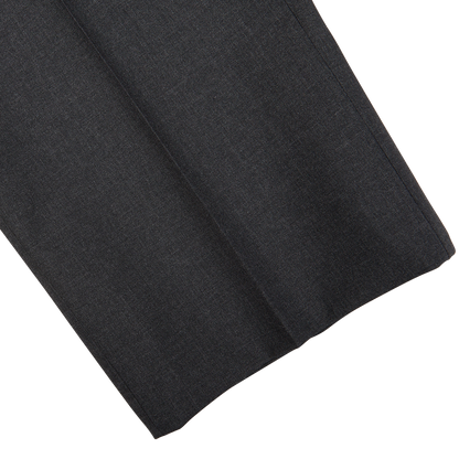 Dark grey Canali tropical wool flat front trousers draped on a white surface.