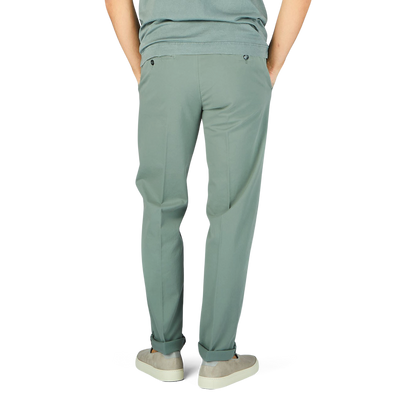 The man is wearing sage green cotton stretch flat front chinos from Canali.