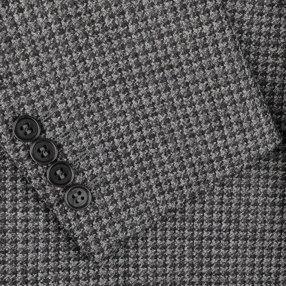 Close-up of the Canali Grey Dogtooth Wool Drop 6 Blazer fabric, featuring a folded edge and showcasing four black buttons arranged in a line, ideal for crafting a sophisticated dark grey blazer.
