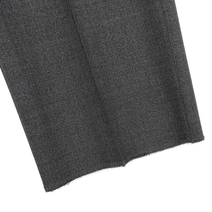 Close-up of a folded piece of textured dark gray fabric with a frayed edge, reminiscent of the refined elegance found in Canali's Grey Melange Wool Flat Front Trousers, ideal for tailored formal wear.