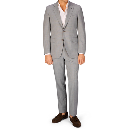 A man in a Canali Light Grey Micro Check Wool Suit and brown shoes standing against a white background.