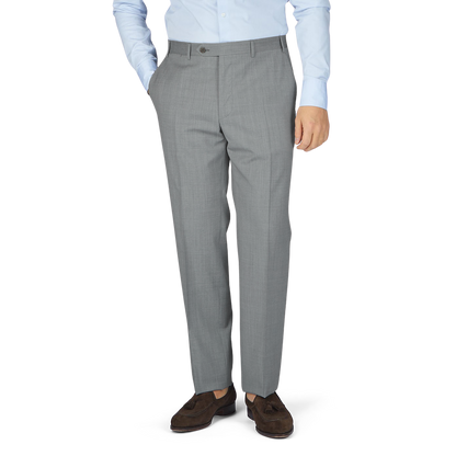 A man dressed in formal attire, sporting Canali Light Grey Micro Check Wool Trousers and a wool fabric blazer.