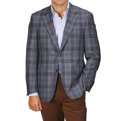A person dressed in the sophisticated Mid Blue Checked Wool Silk Drop 6 Blazer by Canali, stylishly paired with a light blue shirt and brown pants.