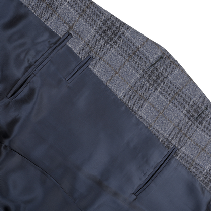 Close-up of the Mid Blue Checked Wool Silk Drop 6 Blazer by Canali, highlighting a plaid-patterned waistband and dark blue fabric in a wool-silk blend, featuring two pockets.