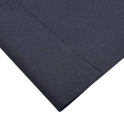 A close-up of a folded piece of fabric showcases the fine, textured weave of Canali's Navy Blue Hopsack Wool Blazer on a light surface.