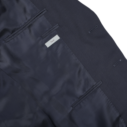 The Canali Navy Blue Hopsack Wool Blazer features an interior label marked "Travel" with two pockets, showcasing elegant Milanese style.