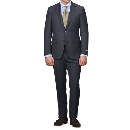 A person wearing a Canali Navy Blue Micro Design Wool Suit exudes classic sartorial elegance against a plain backdrop.