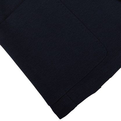 Navy blue cotton stretch jersey fabric with a folded edge on a white surface, Canali's Navy Cotton Jersey Unconstructed Blazer is versatile and stylish.