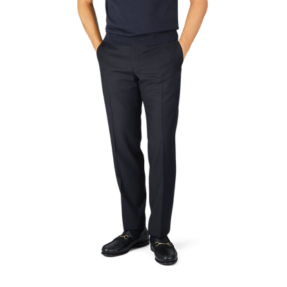 A man wearing Canali Navy Blue Wool Twill Formal Trousers and navy blue shoes.