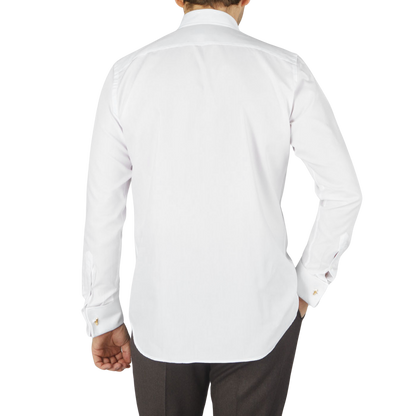 The back view of a man wearing a Canali White Cotton Double Cuff Plain Dress Shirt.