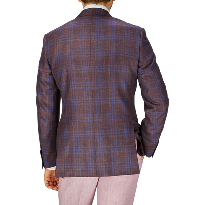 Rear view of a person wearing a Canali wine red checked wool silk linen blazer and light pink trousers, standing against a plain background.