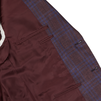Detail of a Canali wine red checked wool silk linen blazer showing the texture of the fabric and pockets on a white background.