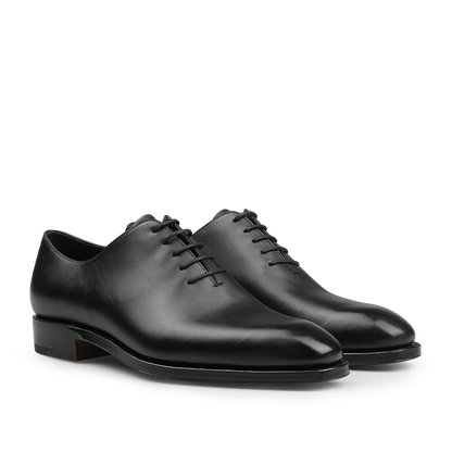 The Carmina Black Calf Leather Wholecut Rain Oxford Shoes are expertly crafted with premium calf leather, featuring round toes and closed lacing, along with a Goodyear welted construction that is visible from the side.