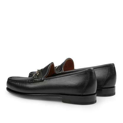 A pair of Carmina Black Funchal Leather Xim Horsebit Loafers with a gold decorative buckle on a white background.