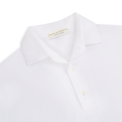 A close-up of the Filippo de Laurentiis White Supima Cotton Jersey Long Sleeve Polo, featuring a classic collar and two white buttons. The shirt is neatly laid on a white background with the label showing "Made in Italy. , available at Richard Gelding Mayfair