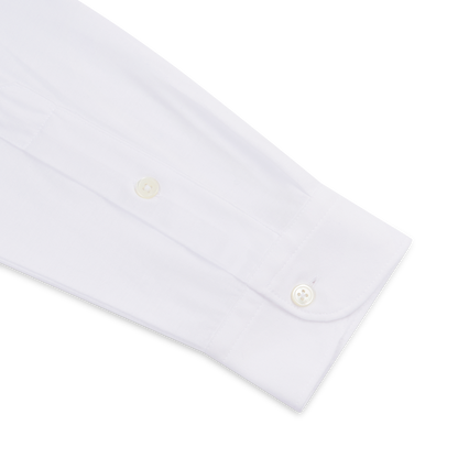 A close-up of the Filippo de Laurentiis White Supima Cotton Jersey Long Sleeve Polo cuff, showcasing small white buttons and smooth, crisp fabric that highlights the shirt’s clean, formal style. , available at Richard Gelding Mayfair