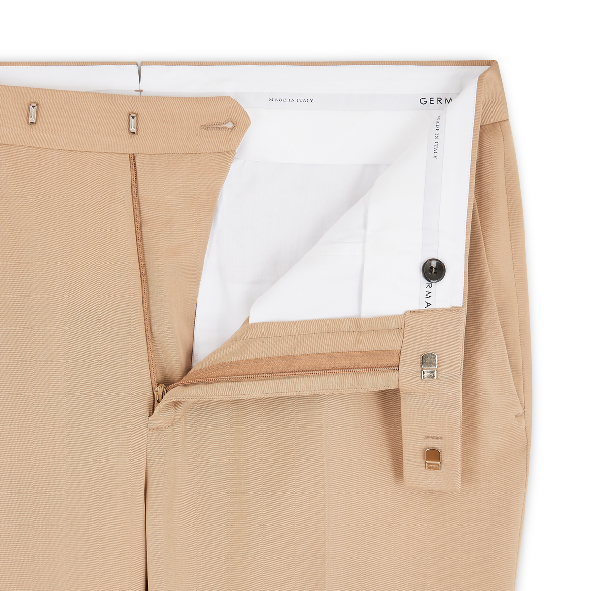 A close-up of Germano Beige Soft Touch Tencel Formal Trouser with open waistband and fly, tan zipper, metal clasp, inner button, and white lining. The label inside reads MADE IN ITALY and partially shows the brand name. , available at Richard Gelding Mayfair