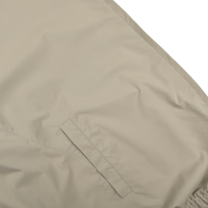 Close-up of a Fedeli Beige Nougat Nylon Reversible Blouson Jacket made from water-resistant nylon, highlighting visible stitching and a horizontal slit pocket.