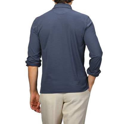 A person wearing Fedeli's Dark Blue Organic Cotton LS Polo Shirt and beige pants is shown from the back against a neutral backdrop.