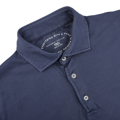 The Fedeli Dark Blue Organic Cotton LS Polo Shirt offers luxurious casual-wear with timeless elegance, featuring a three-button collar and the text "Everything with a past, nothing forgotten.