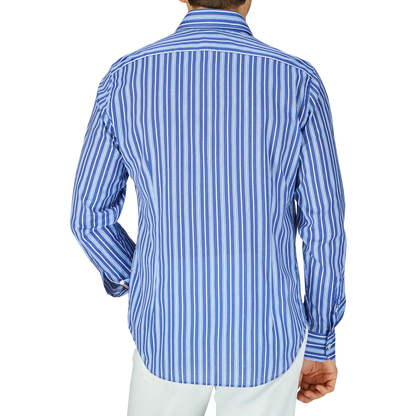 A person from behind wearing a Fedeli Dark Blue Striped Cotton Beach Shirt with white pants.