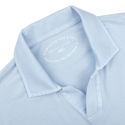 Close-up of the Light Blue Organic Cotton Capri Collar Polo Shirt by Fedeli, showcasing the text: "Everything with a past is working for the future. Fedeli. Organic Giza Cotton." This shirt epitomizes luxury casual wear.