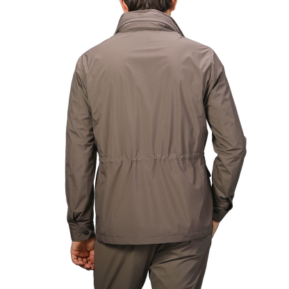 A person wearing a Fedeli Light Brown Nylon Rainproof Field Jacket and pants stands with their back to the camera against a light gray background.