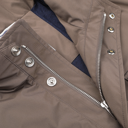 A close-up of Fedeli's Light Brown Nylon Rainproof Field Jacket showcases its silver zipper and button closures against a dark fabric backdrop. The wind and water-resistant design ensures both style and practicality.
