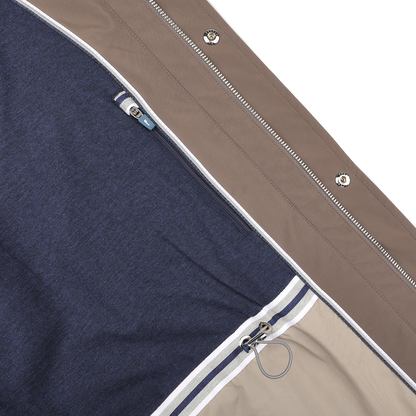 Close-up of Fedeli's Light Brown Nylon Rainproof Field Jacket showcasing a brown outer layer, blue inner lining, striped border, and wind-resistant design with a small clip near the zipper.