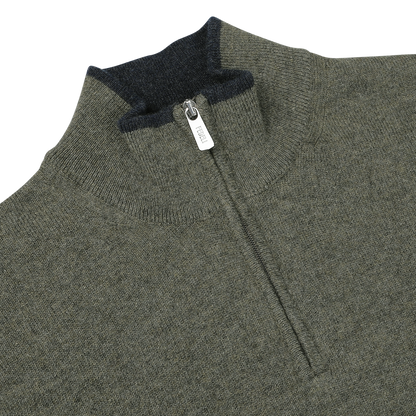 Close-up of a moss green wool-cashmere 1/4 zip sweater with a dark gray inner collar. The zipper pull is visible and labeled "Fedeli." The fabric has a knit texture.