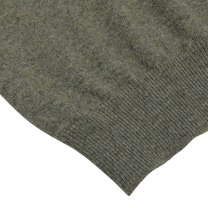 Close-up of a moss green knitted fabric from Fedeli's Wool Cashmere 1/4 Zip Sweater, showcasing its texture and neat stitching along the edge.