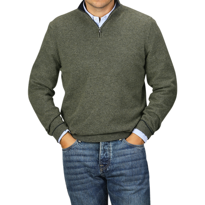 A person wearing a Moss Green Wool Cashmere 1/4 Zip Sweater from Fedeli over a light blue collared shirt and blue jeans stands with hands in pockets.