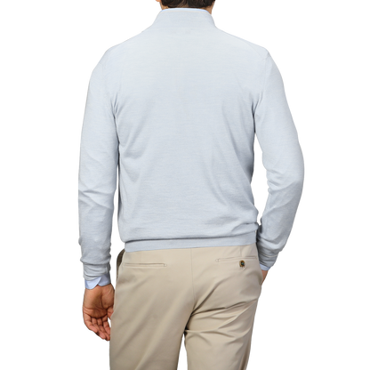 The person is seen from the back in a Fedeli Sky Blue Cashmere Silk 1/4 Zip Sweater, paired with beige trousers against a neutral backdrop.