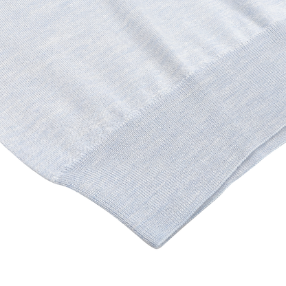 Close-up of the Sky Blue Cashmere Silk 1/4 Zip Sweater by Fedeli, highlighting the textured knitted fabric and ribbed edge.