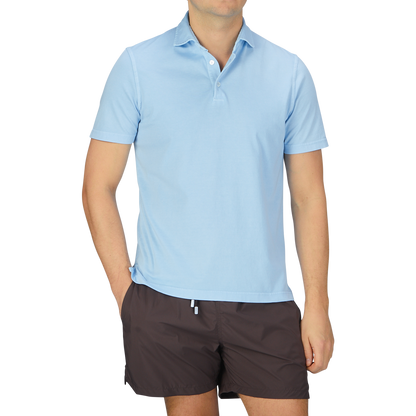 A man wearing a luxury Fedeli Sky Blue Organic Cotton Polo Shirt.