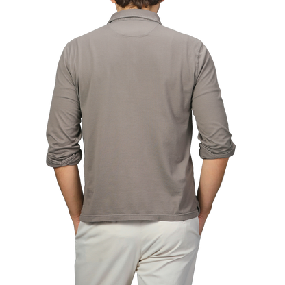 A person is shown from the back wearing a Taupe Beige Organic Cotton LS Polo Shirt by Fedeli and beige pants.