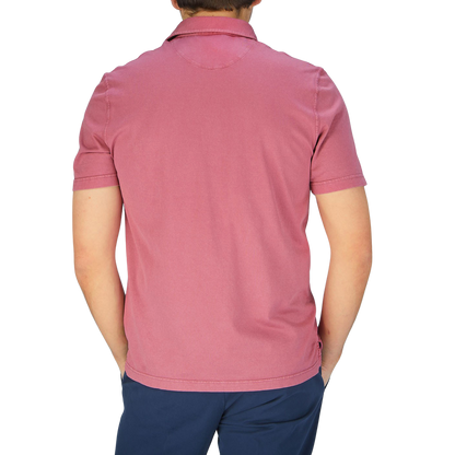 The back view of a man wearing a Fedeli Washed Raspberry Organic Cotton Polo Shirt.