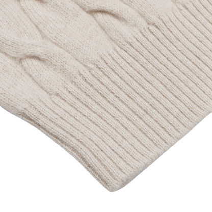 Close-up image of a cream knit cardigan by Filippo de Laurentiis, featuring a ribbed cuff and intricate cable-knitted pattern, showcasing luxurious wool and cashmere blend.