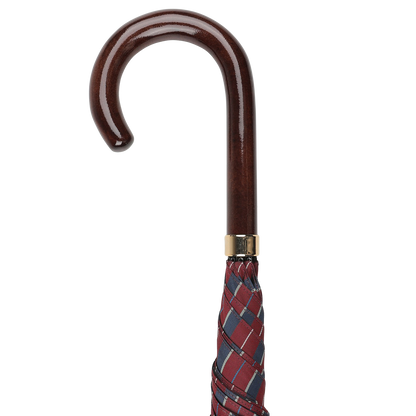 A handmade Fox Umbrellas creation, the Red Blue Striped Maple Handle Umbrella features a wooden crook handle and a burgundy and blue checkered fabric, rolled and closed.