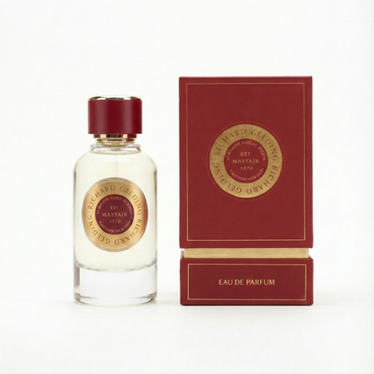 A clear glass bottle with a gold and red cap stands by a matching box, both labeled Richard Gelding Sultan EdP 100ml—a refined fragrance from Richard Gelding in elegant lettering. , available at Richard Gelding Mayfair