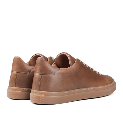 A pair of Goral's Brown Horween Leather Mellor II Sneakers, showcasing premium-quality craftsmanship with beige soles, viewed from the back.