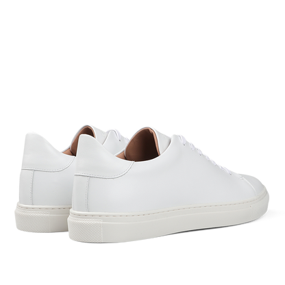The White Calfskin Mellor II Sneakers by Goral, featuring white laces and a beige inner lining, showcase the craftsmanship of this British footwear brand. These premium sneakers perfectly combine style and comfort when viewed from the back and side.