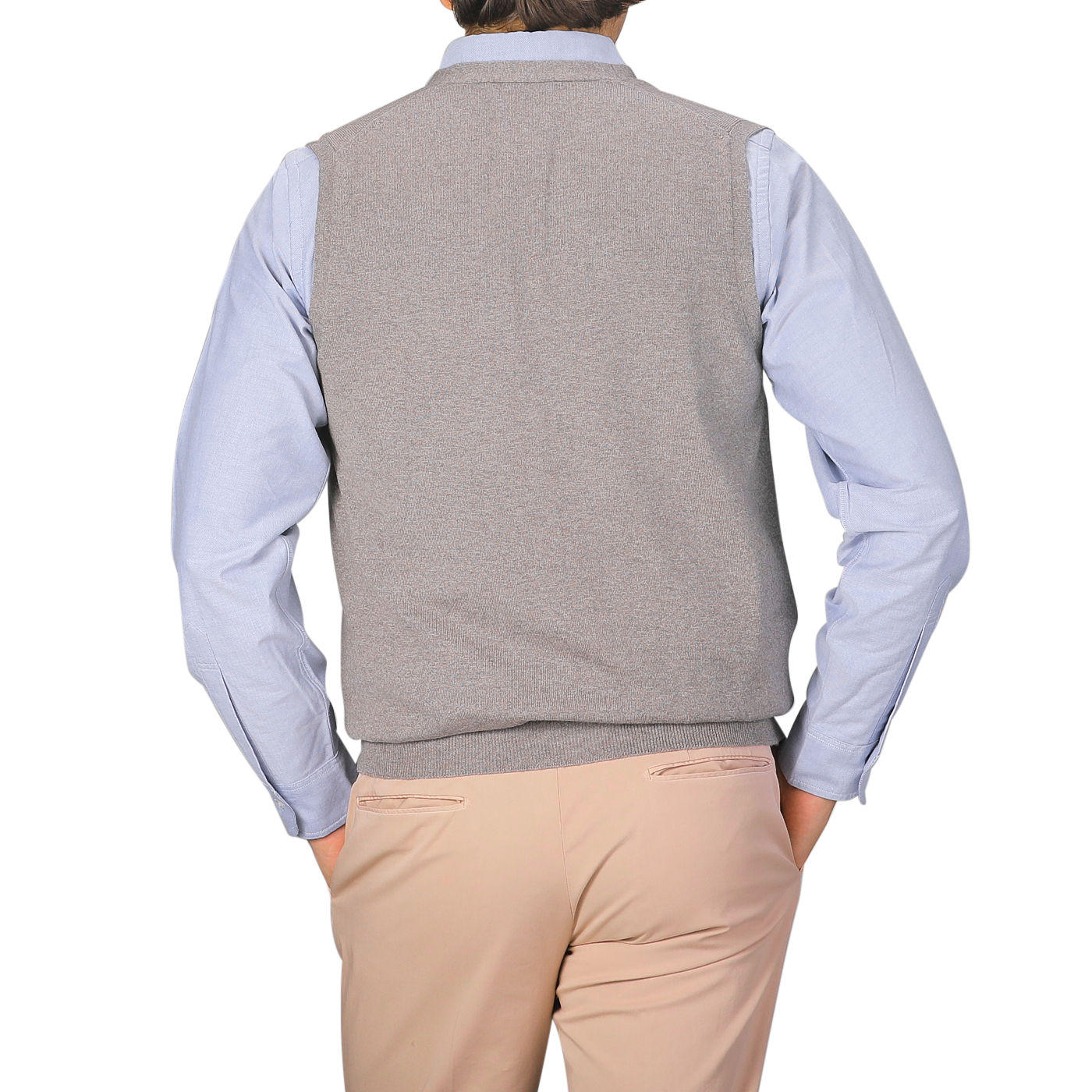 A person is shown from the back, hands in pockets, wearing a light blue dress shirt and Gran Sasso's Beige Extra Fine Merino Wool Vest, paired with beige pants against a plain background.