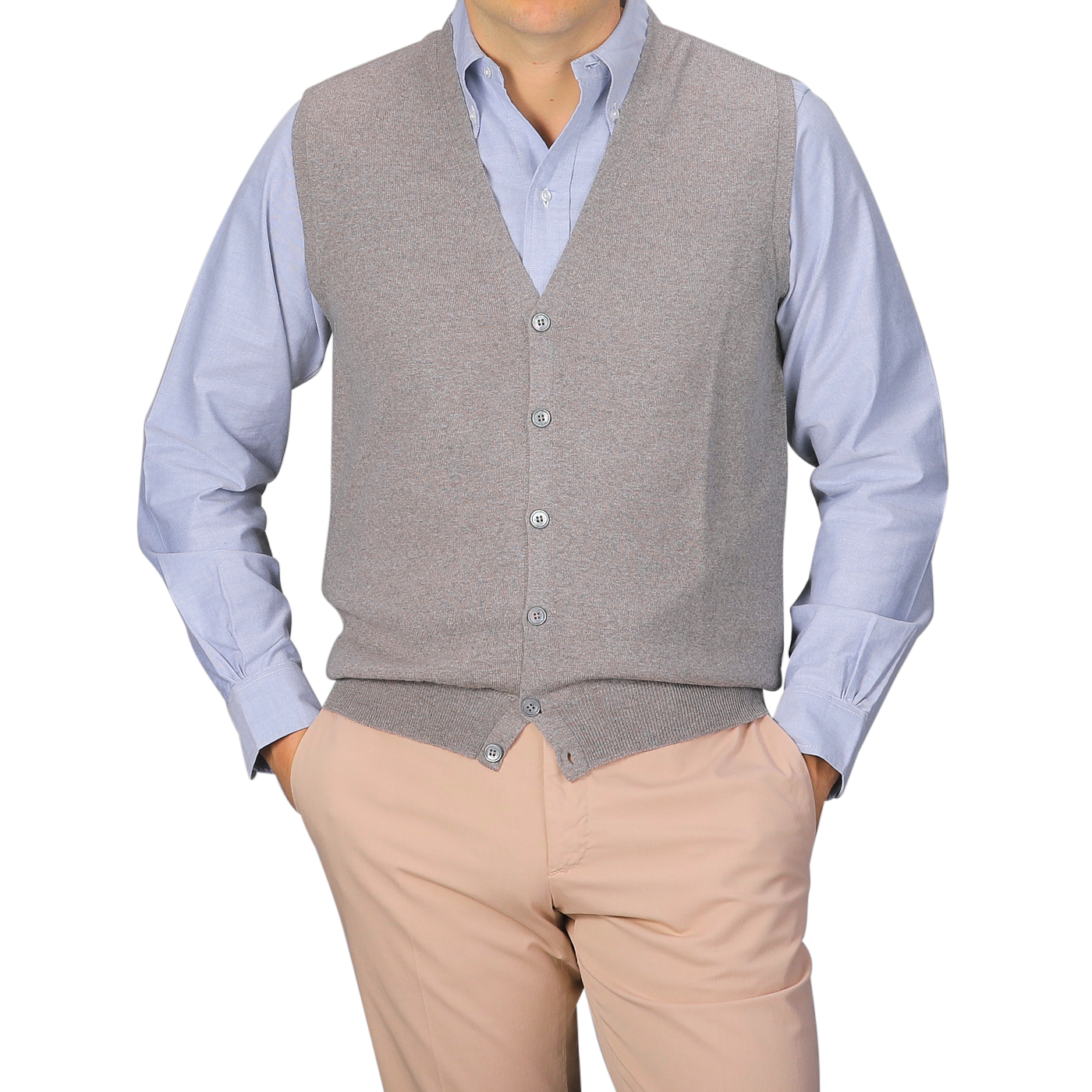 A person wears a light blue button-up shirt, hands in pockets, layered with the Gran Sasso Beige Extra Fine Merino Wool Vest and light beige pants, shown from shoulders to waist.