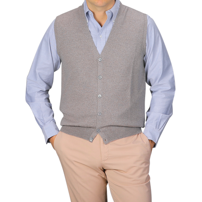 A person wears a light blue button-up shirt, hands in pockets, layered with the Gran Sasso Beige Extra Fine Merino Wool Vest and light beige pants, shown from shoulders to waist.