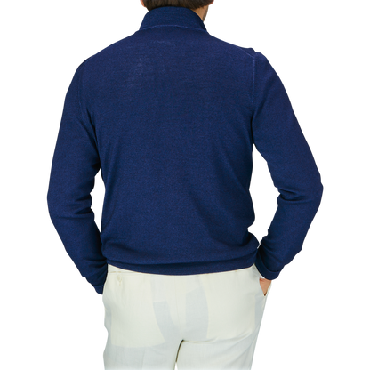 Man facing away from the camera wearing a Gran Sasso Blue Melange Vintage Merino Wool Zip Cardigan with a vintage feel and light-colored pants.