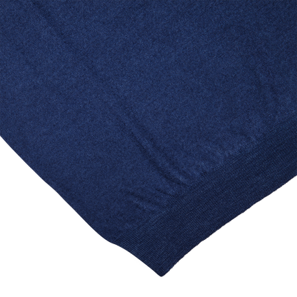 A close-up of a Gran Sasso Blue Melange Vintage Merino Wool Zip Cardigan fabric with a noticeable texture, possibly denim, displayed on a diagonal angle.