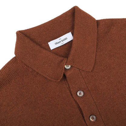 The Gran Sasso Burnt Orange Virgin Wool LS Polo Shirt features a collared design with three buttons and a visible label inside the collar, offering a regular fit crafted from virgin wool.