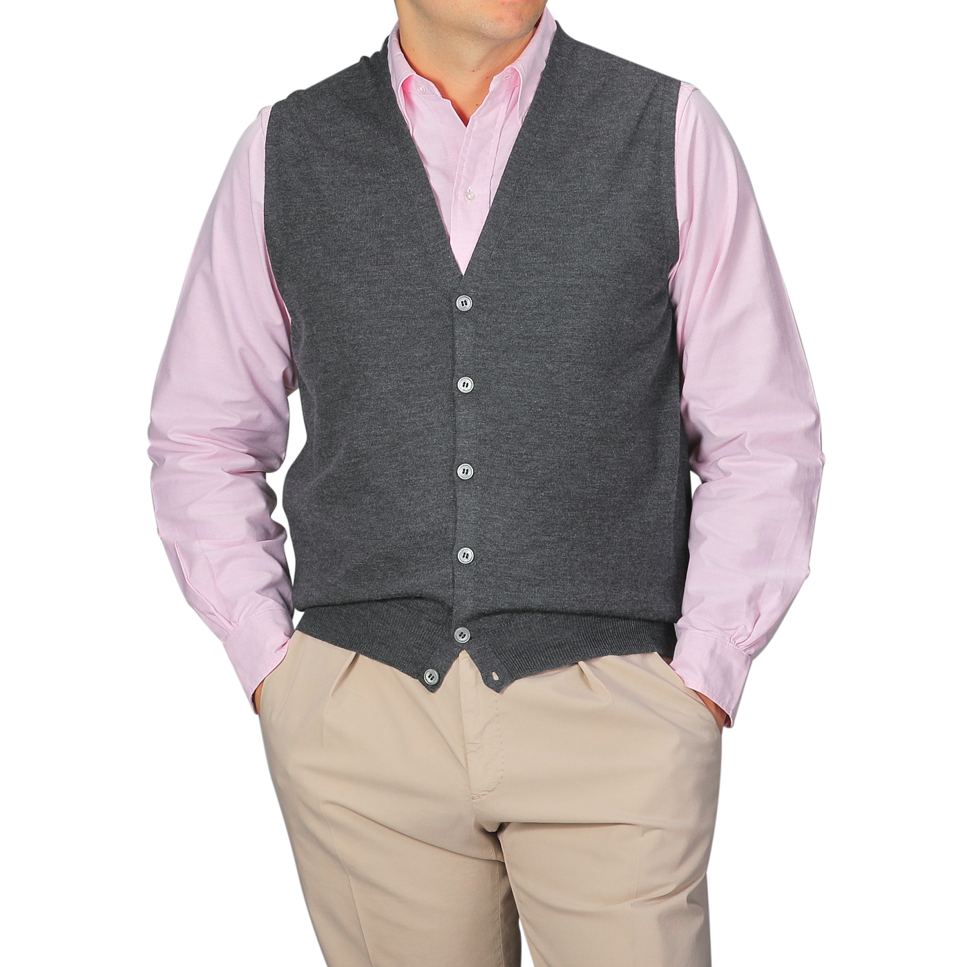 A person layers a light pink button-up shirt with the Gran Sasso Charcoal Extra Fine Merino Wool Vest and beige pants, hands in their pockets.