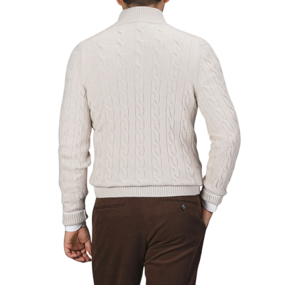 A person wearing a cream Pure Cashmere Quarter Button Sweater from Gran Sasso and brown pants is shown from the back against a plain background.